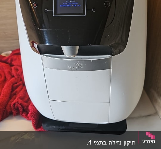 מכונת מים על משטח במטבח עם מגבת אדומה